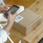 Seseorang memindai kode QR pada paket menggunakan smartphone